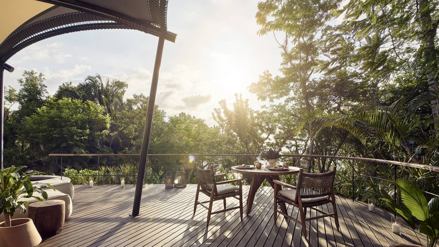Wooden deck with dining table for two, surrounded by trees