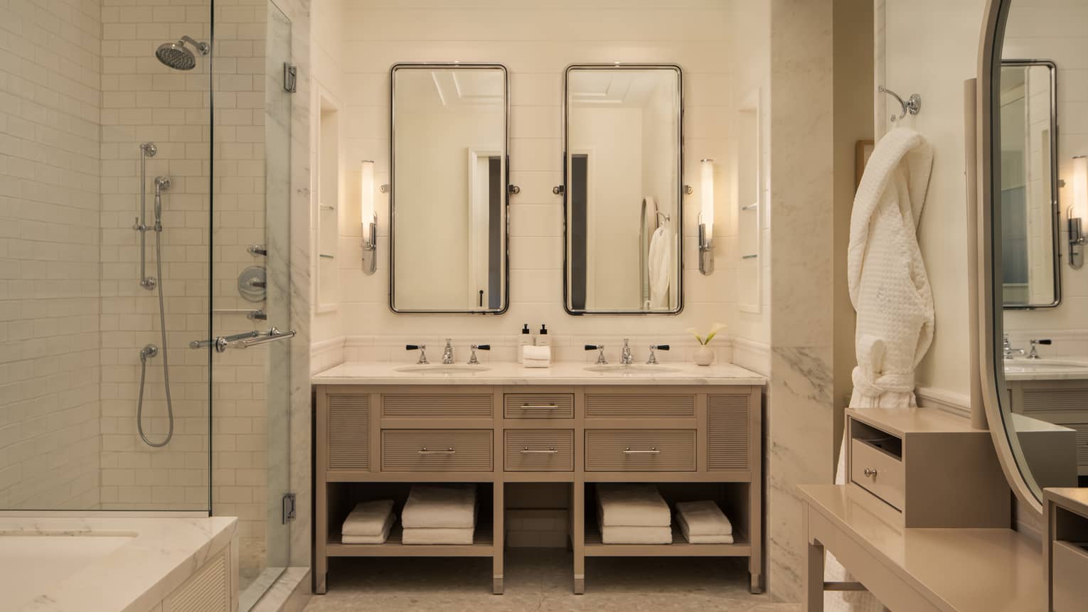 Luxury hotel bathroom with double vanity, glass-enclosed shower and bath tub