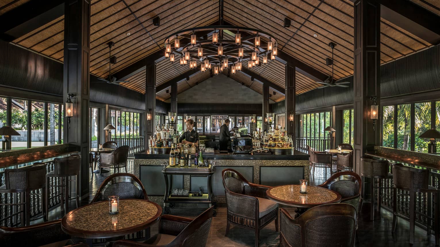 Bartenders at The Bar under cathedral ceiling with large lantern chandelier