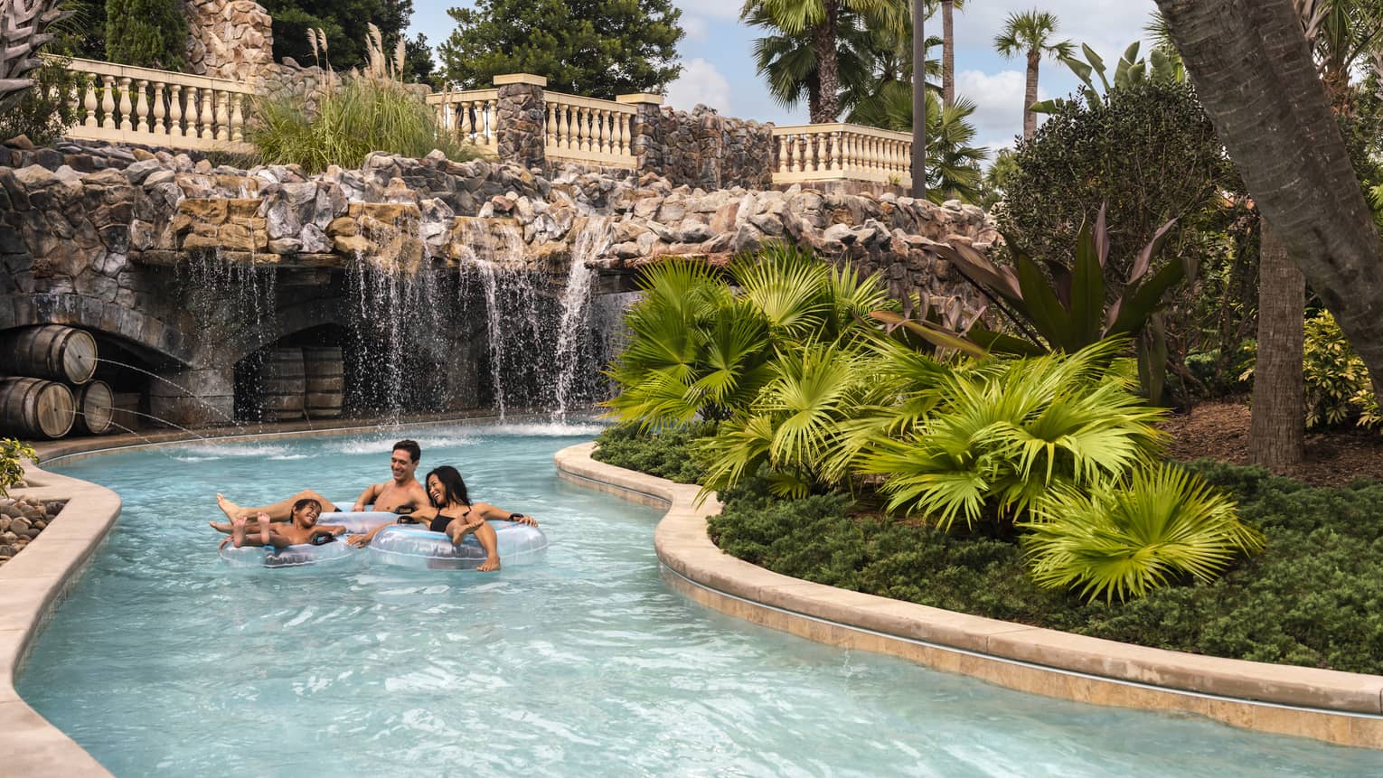Two adults and a child ride in light-blue inner tubes along the Resort's outdoor lazy river