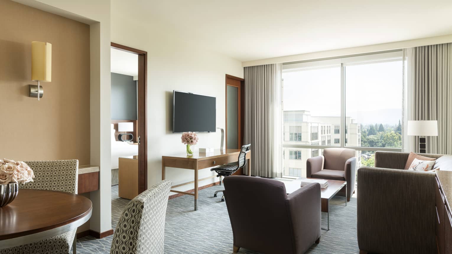 Silicon Valley Suite sunny seating area, dining table, TV, door to bedroom
