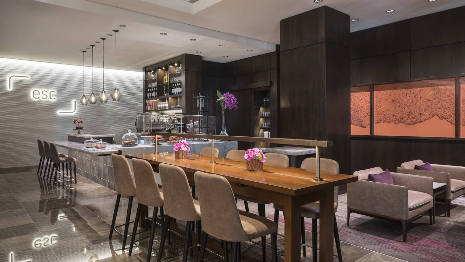Dining room with long communal table, stone and marble bar, modern light, sign