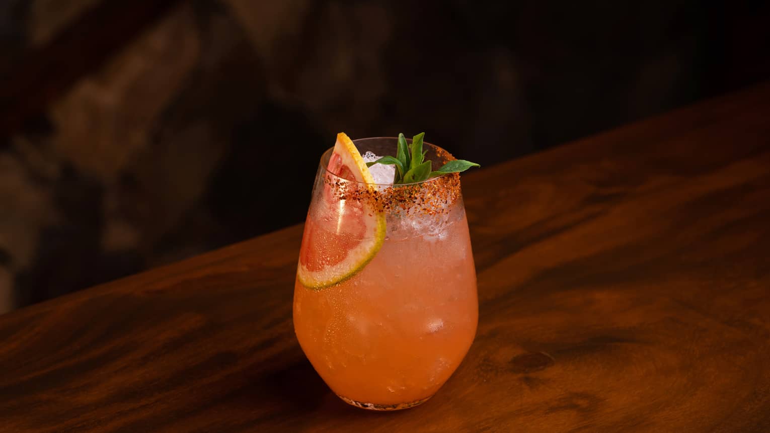 A light orange cocktail with a grapefruit slice in it.