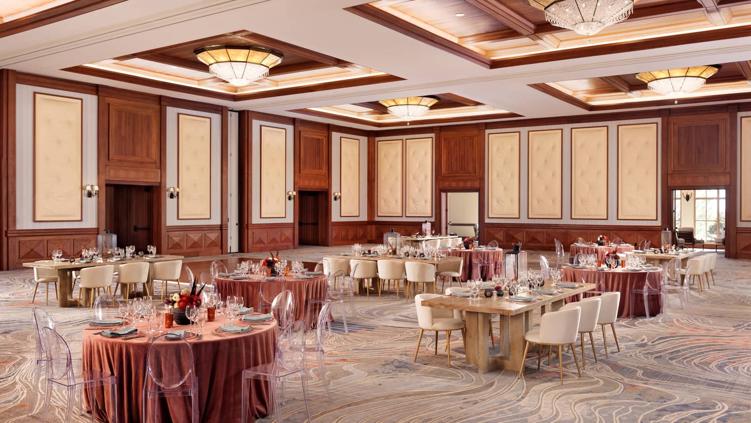 A room with large round and rectangular tables covered in pink cloth.