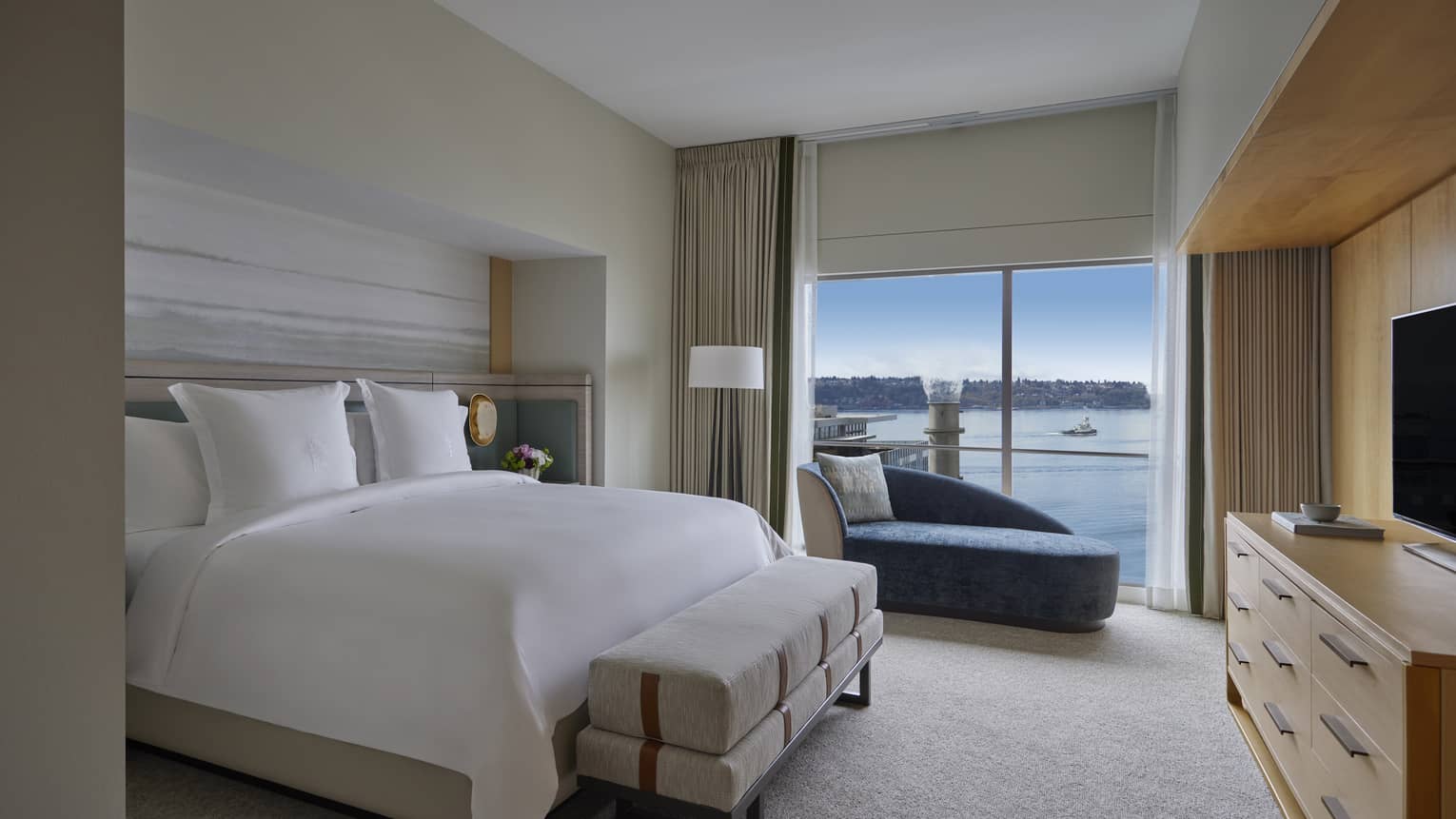 Bedroom with king bed, dresser and TV, and windowside chaise