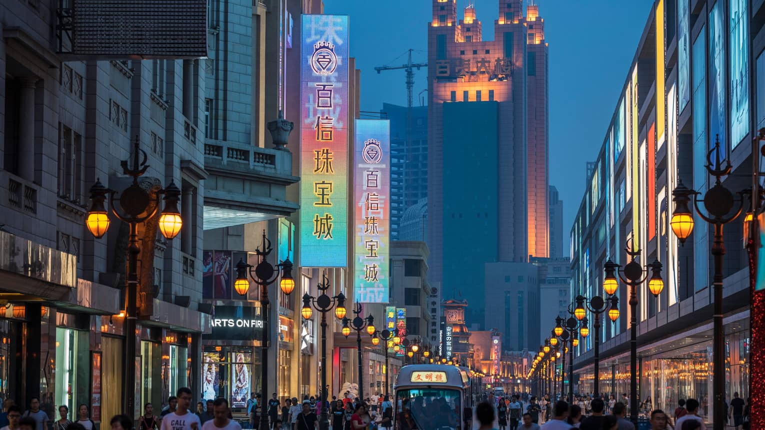 Binjiang Avenue shopping district, pedestrians on busy sidewalk under stores, signs
