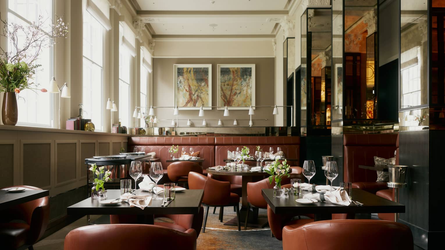 Restaurant featuring square black tables with tan leather chairs