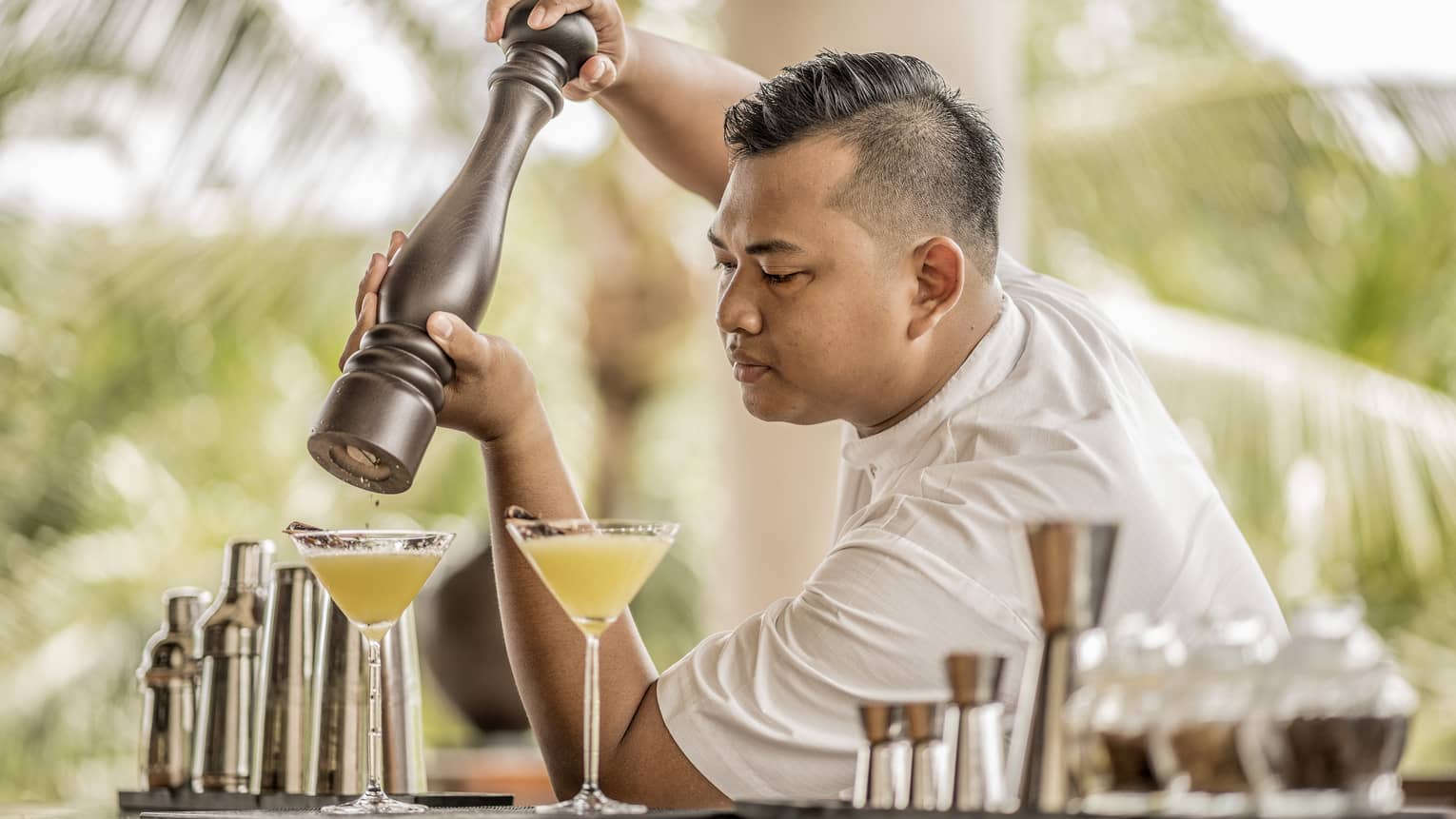 A bartender garnishing a drink with spices in Bali