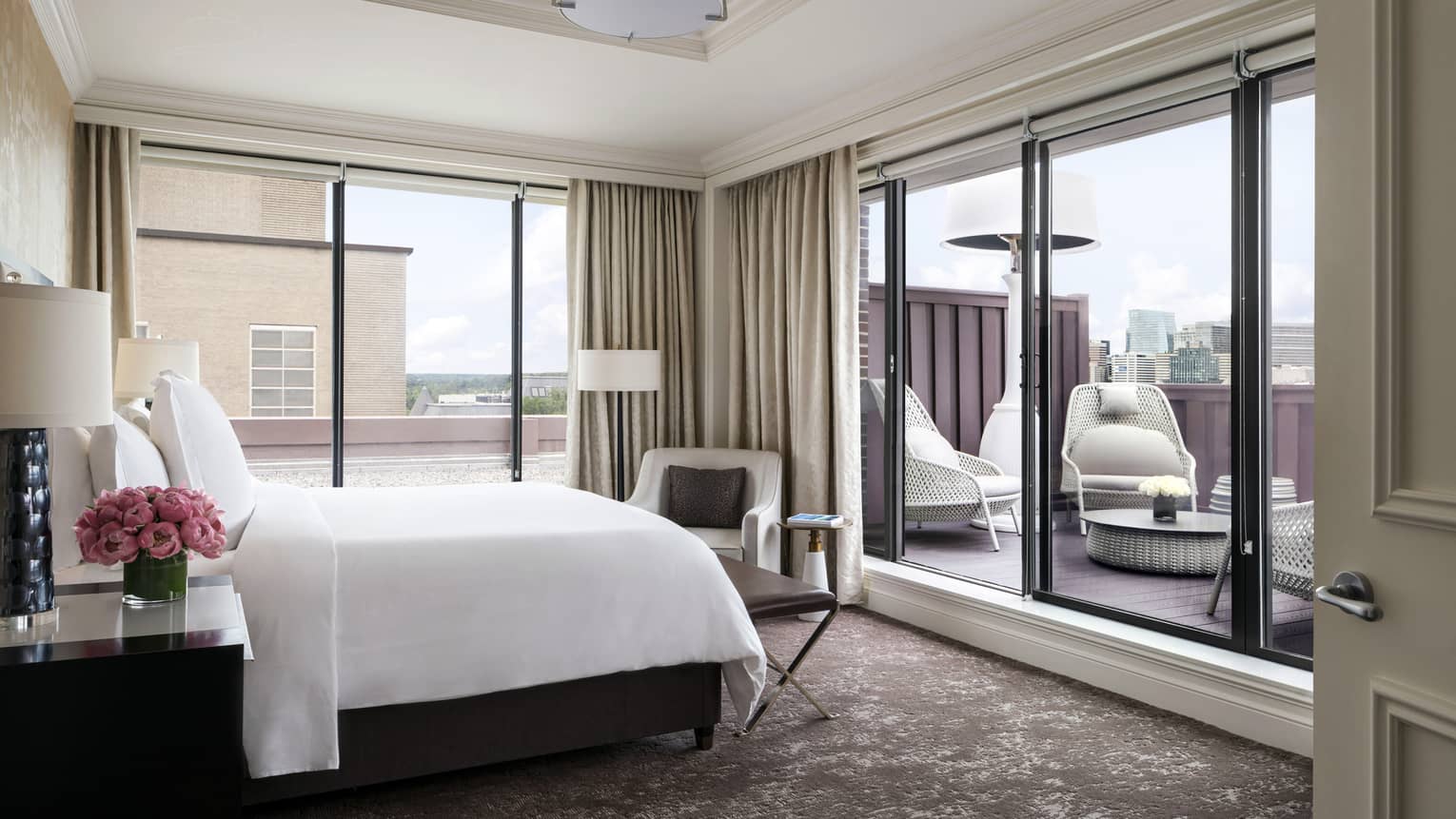 A well-lit suite with a sliding door leading outside to a private terrace