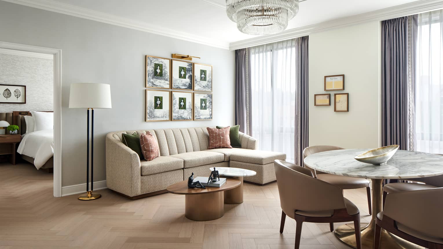 Luxury hotel suite living room and round marble dining table for four, leading into separate bedroom, at Four Seasons Hotel Washington, DC