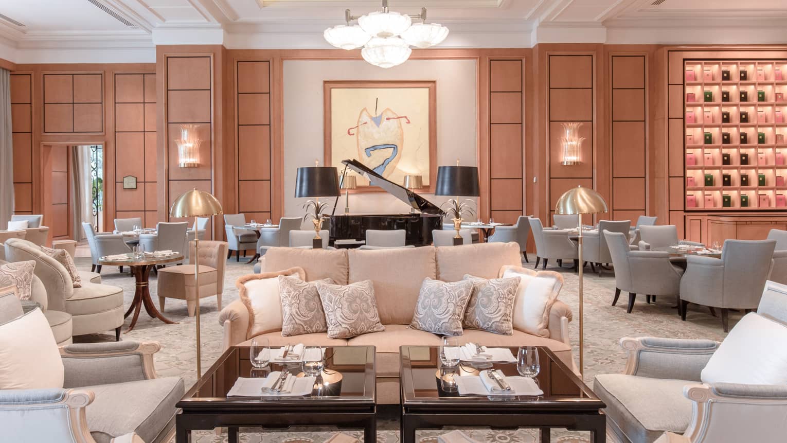 Large lobby with multiple neutral seating areas, black baby grand piano, modern art on wall