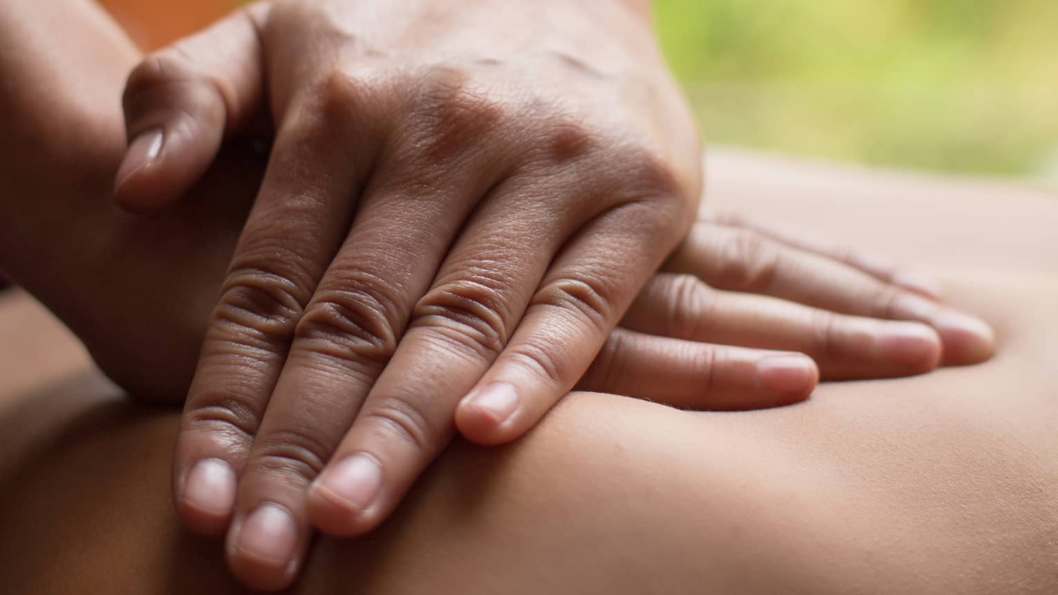 Close up of hands massaging a back