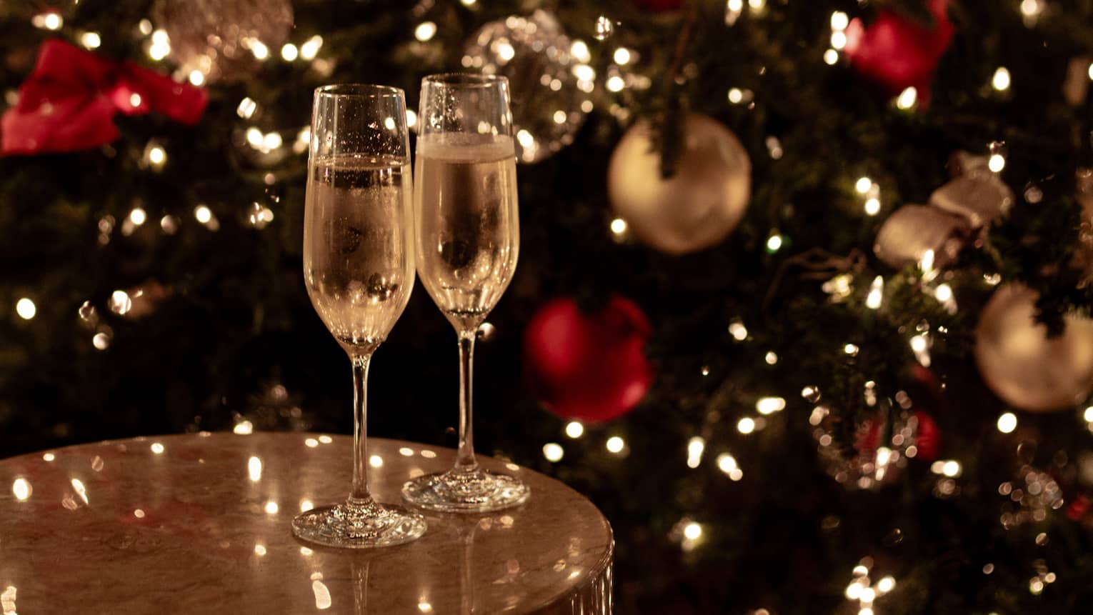 Joyous champagne toast with festive lights for Tokyo Christmas and New Year’s Eve celebrations.