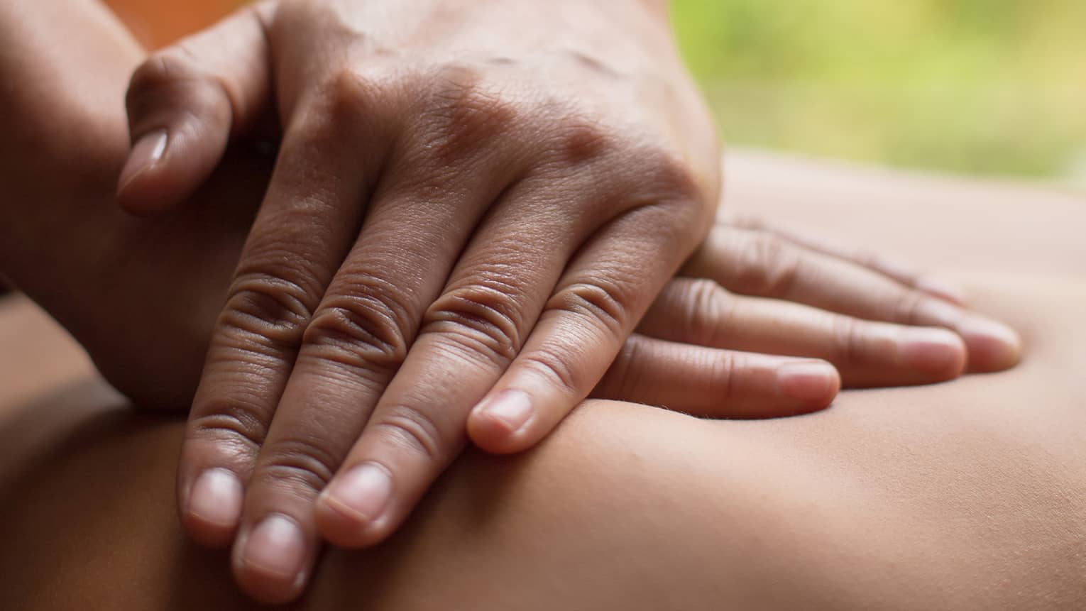 Close up of hands massaging a back