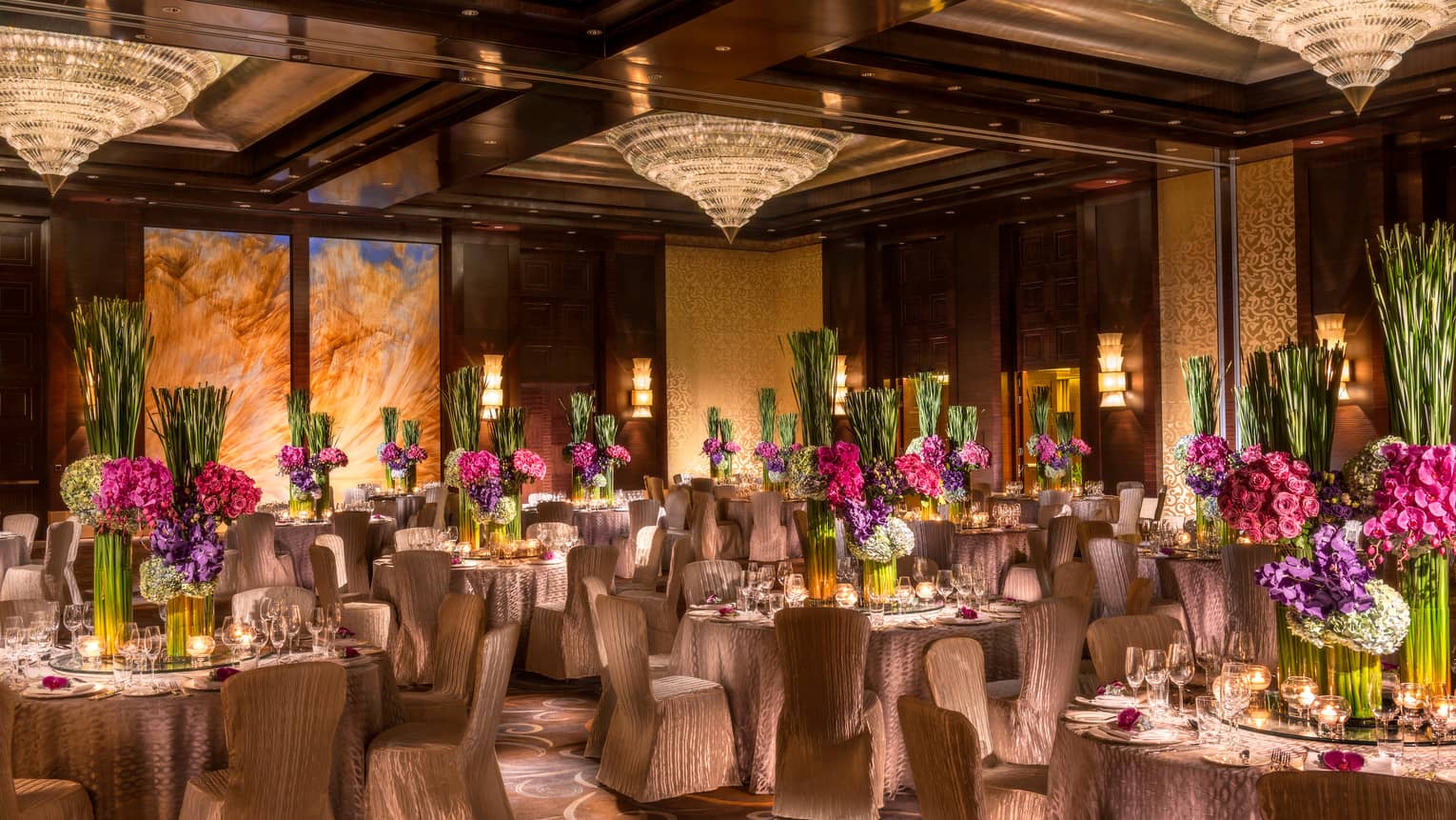 Imperial Ballroom wedding reception with fabric-covered chairs, floral centrepieces, crystal chandeliers
