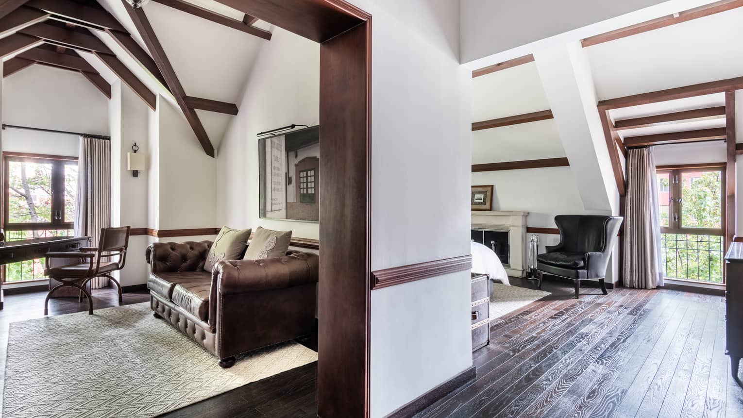 Chocolate leather couch with accent pillows, area rug visible through doorway, accent chair, door leading to balcony on the right