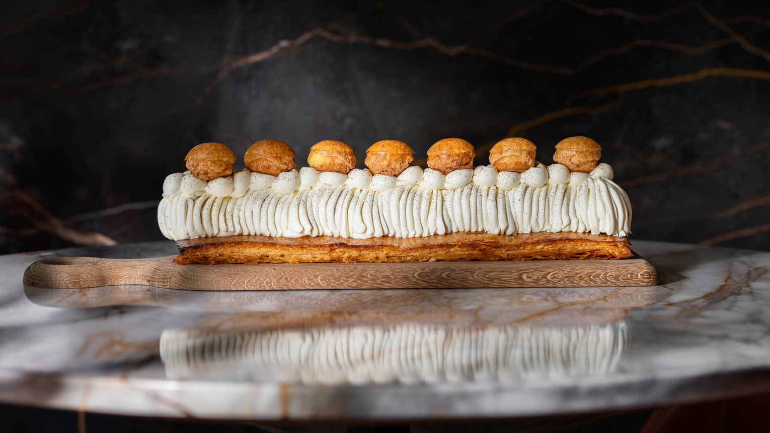 St. Honor� cake on board atop marble table