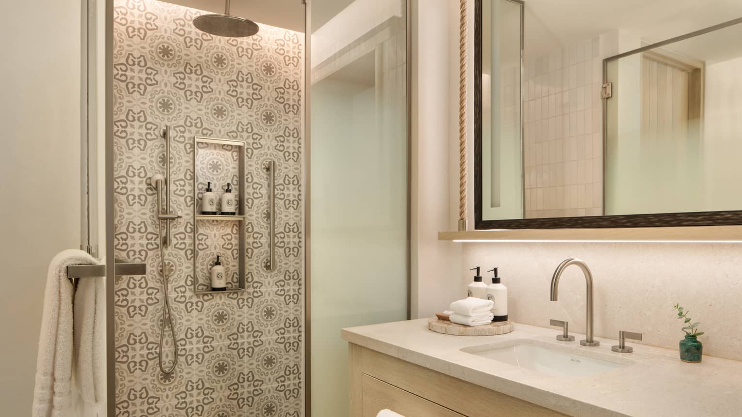 Bathroom featuring a walk-in shower with grey and white tiled wall