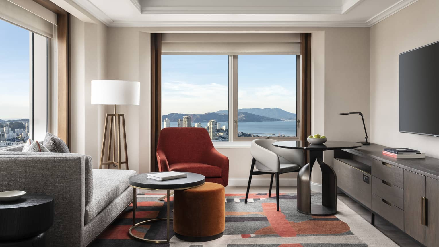 Living area in a hotel room, with corner views of San Francisco and bay