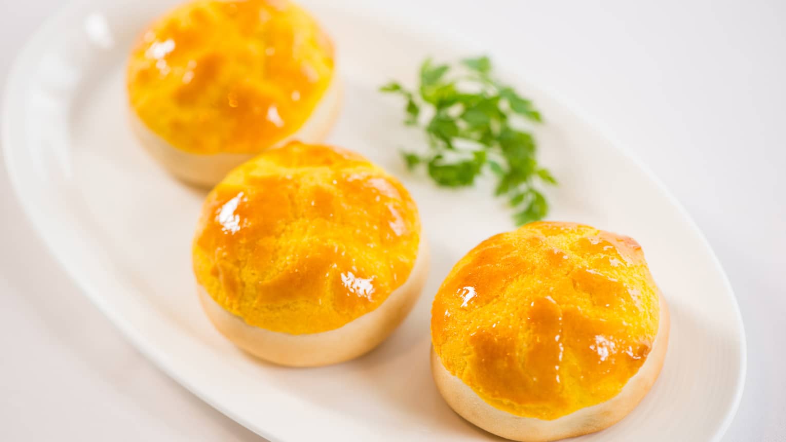 Three Baked Barbecued Pork Buns with Pine Nuts on White Plate