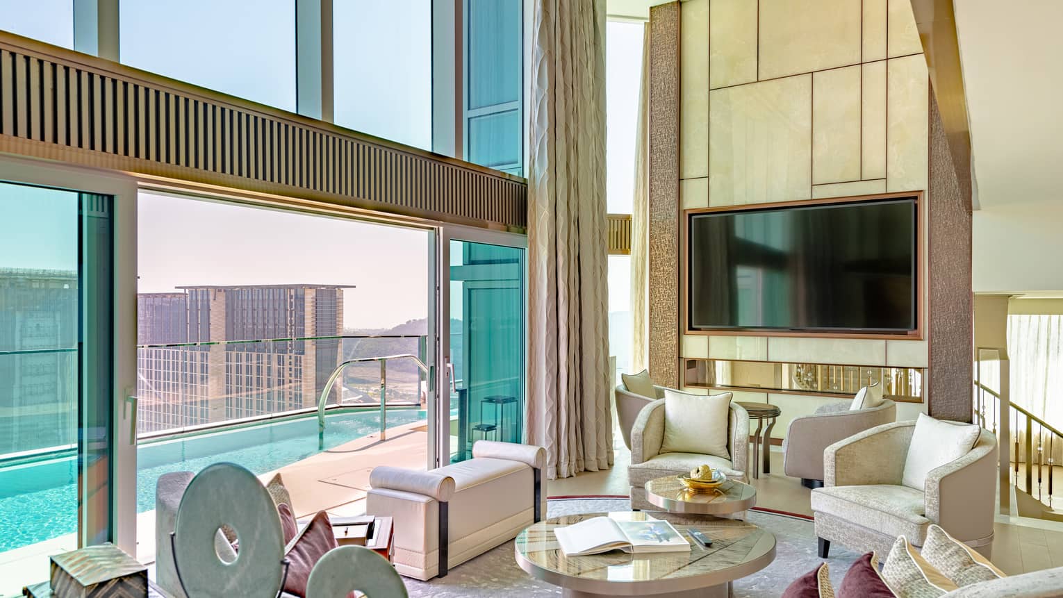 Sky View Villa living room with double-tall ceilings and windows overlooking a pool