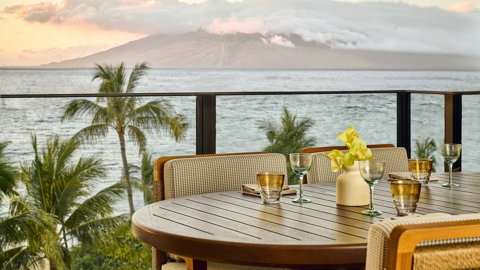Outdoor dining table on a balcony with ocean and Hawaiian island view