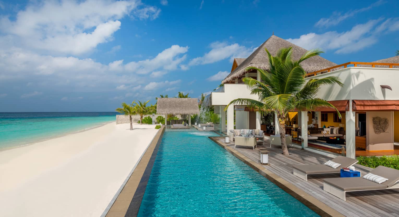Three-Bedroom Landaa Estate villa deck by long swimming pool, white sand beach and ocean