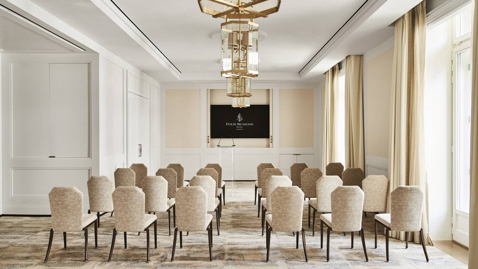Classroom-style meeting room setup with TV screen at the front of the room.