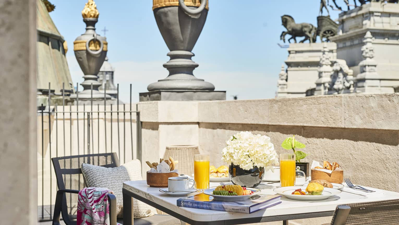 Dining table with two chairs on private terrace, with view of Madrid statue