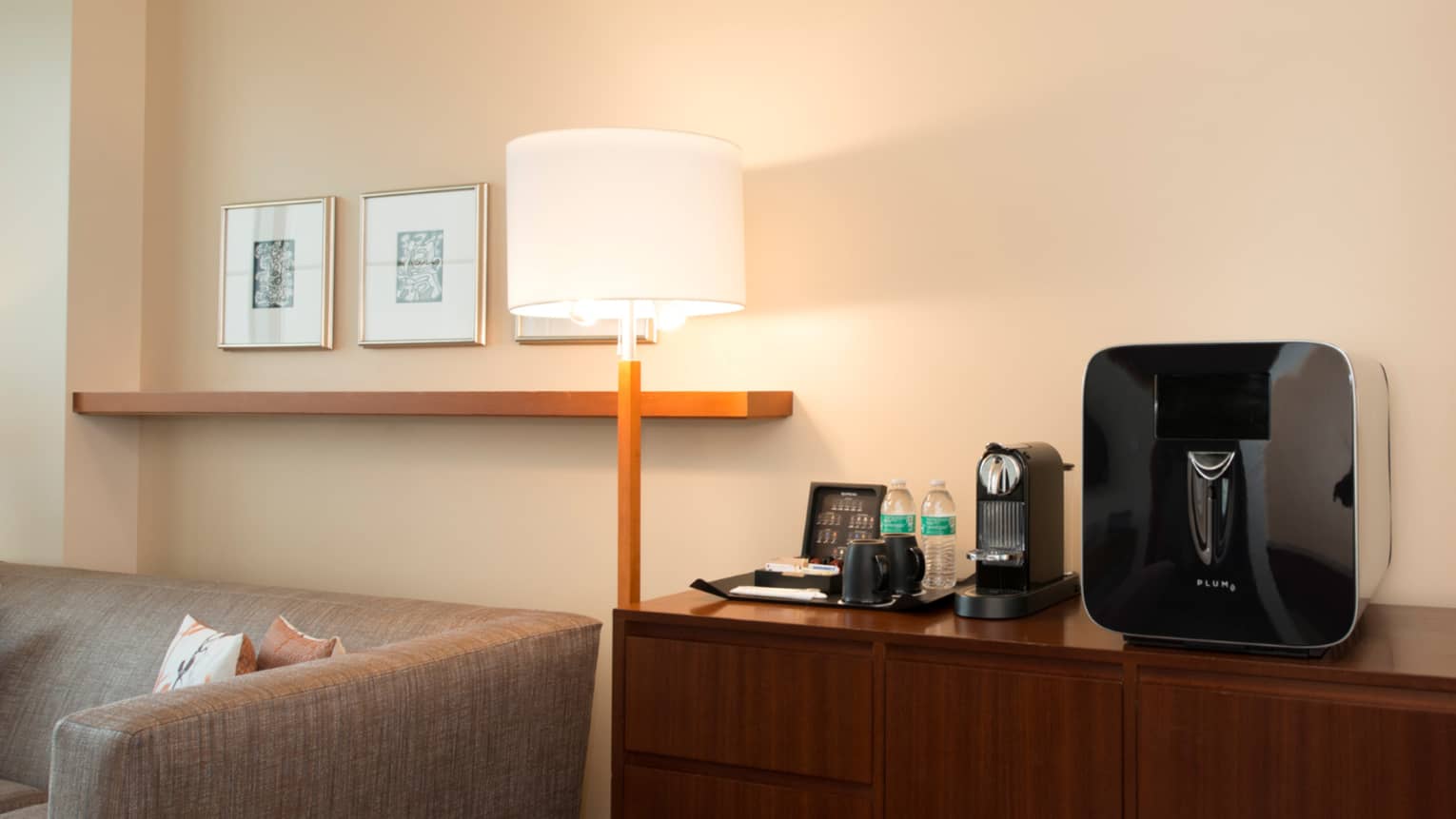 Lamp by retro-style dresser with bottled water, coffee machine