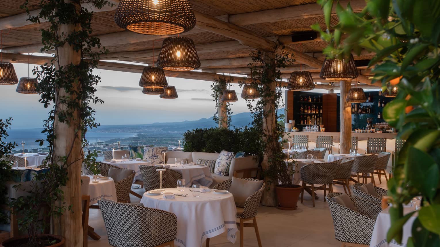 Outdoor terrace restaurant with hanging whicker lights, sea view