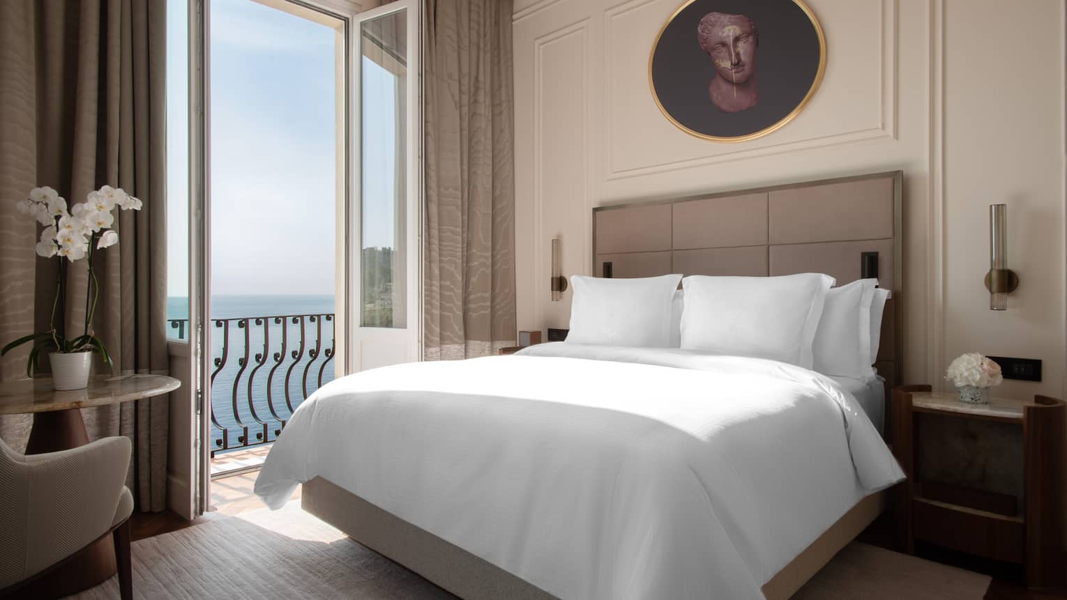 Hotel room with king bed, tan leather headboard, sea-view Juliet balcony