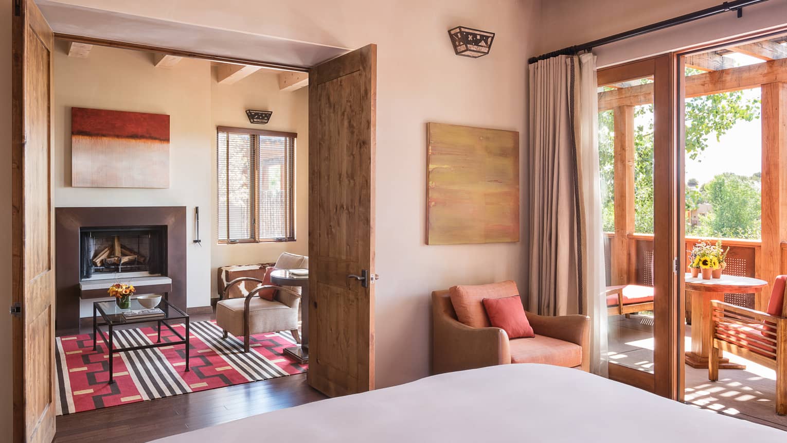 Sunset, Summit Suite bed, chair, open wood doors to seating area, sunny balcony