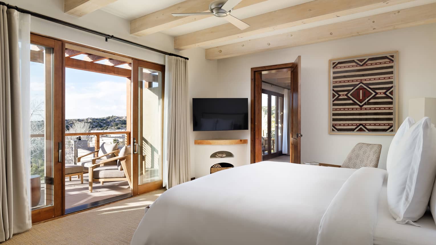 Guest room with king bed, TV, and walk-out balcony at Four Seasons Resort Santa Fe