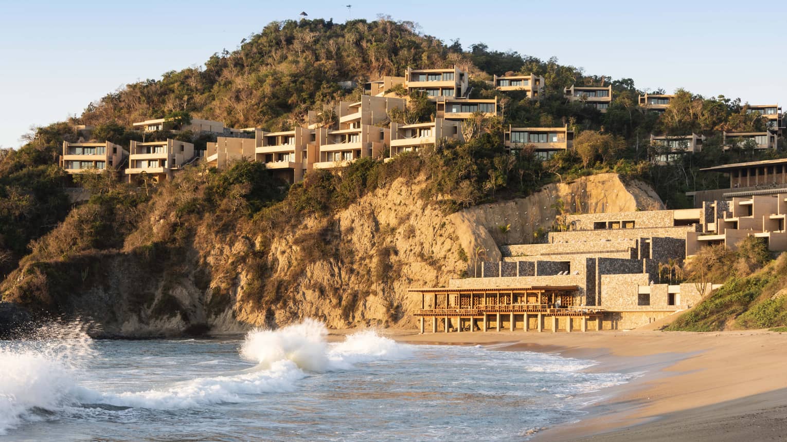 Resort suites perched on a cliff overlooking the ocean and beach