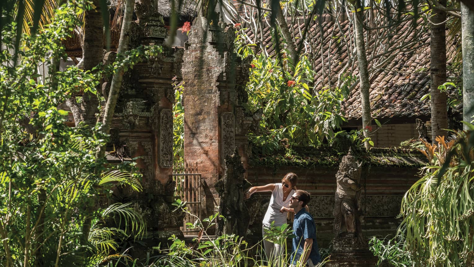Gusts exploring decorative statues surrounding a temple in Bali