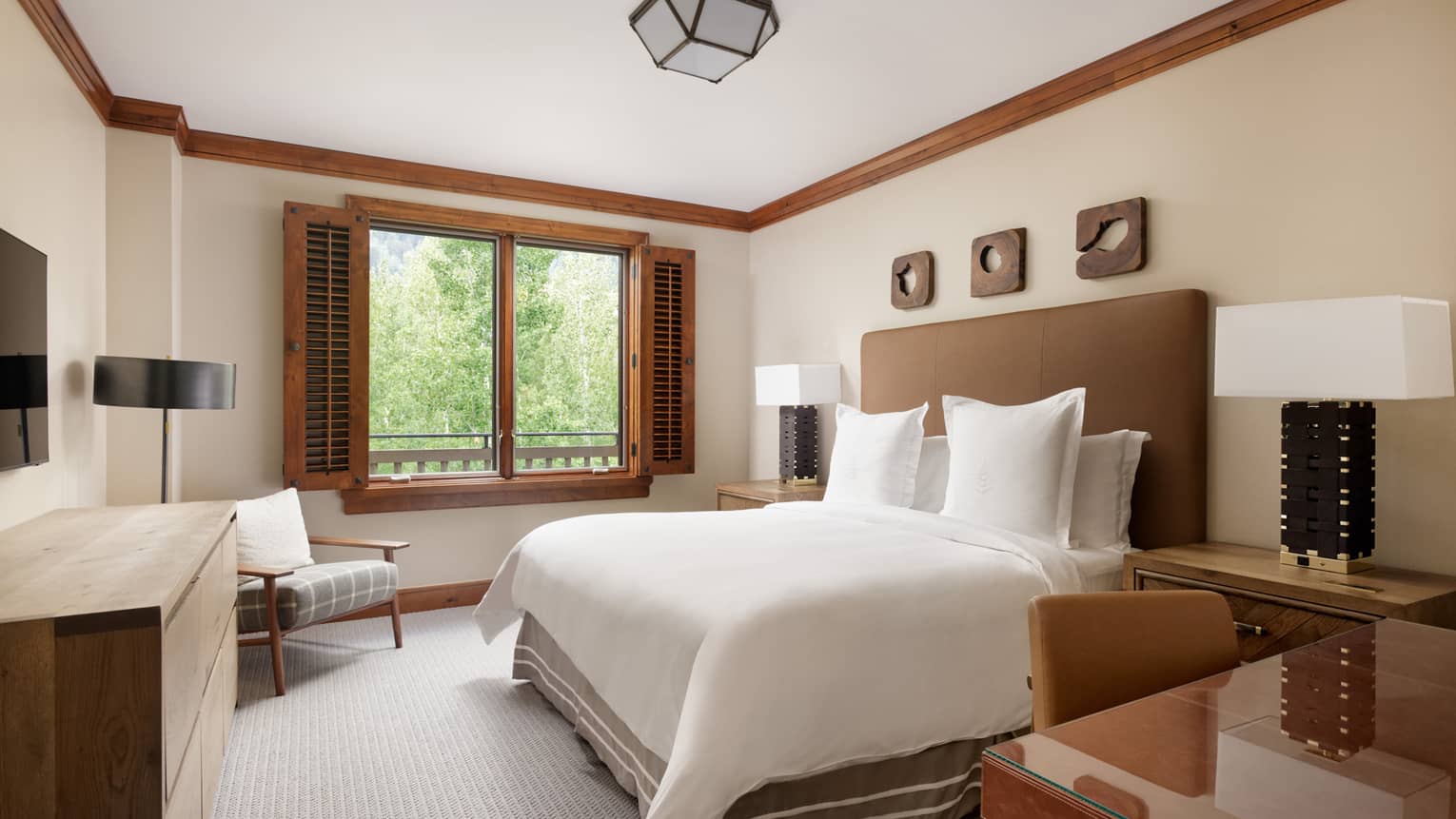 Bedroom with king bed, desk, dresser, chair and window