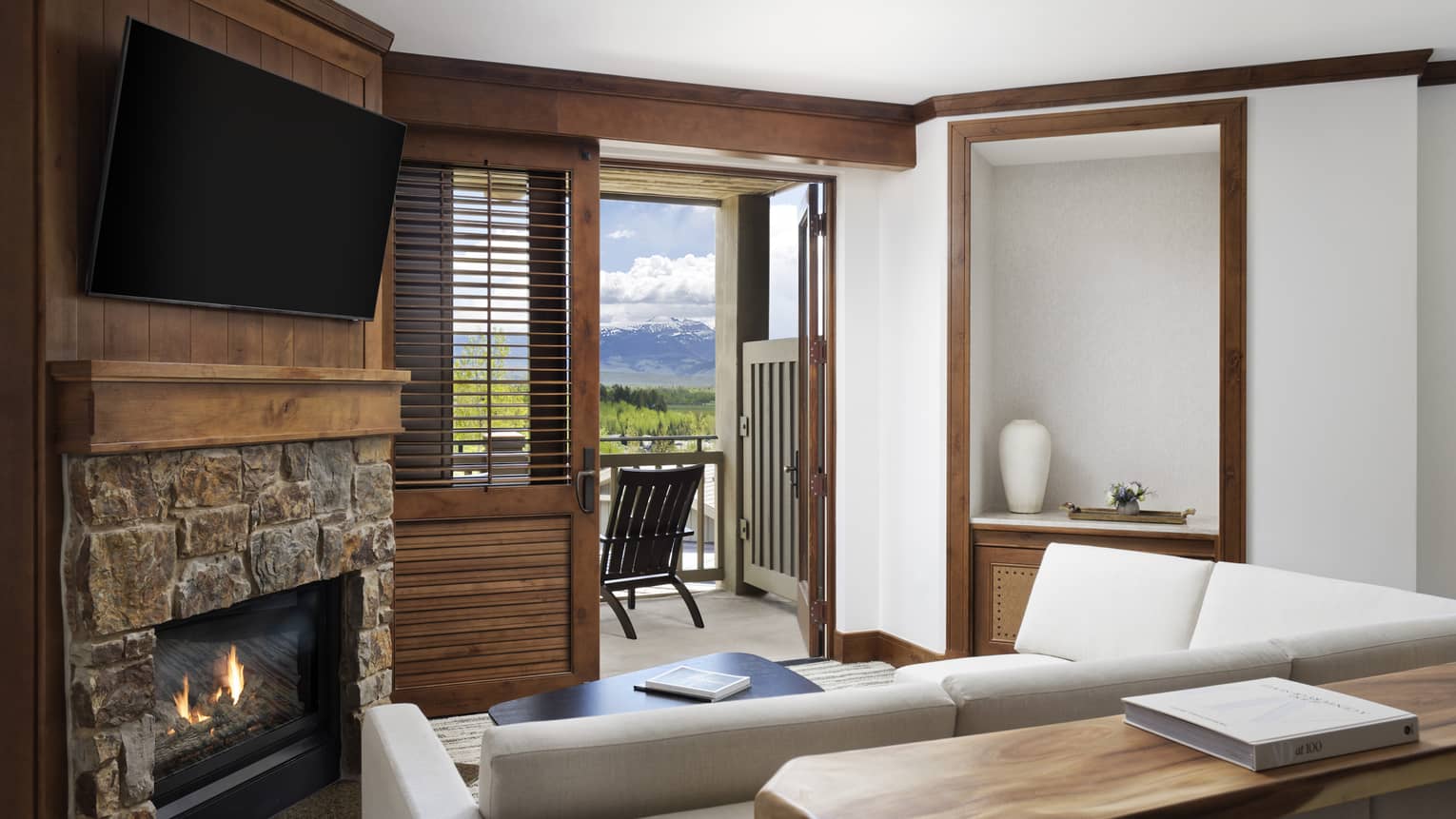 Living room with sofa, fireplace, wall-mounted TV and balcony