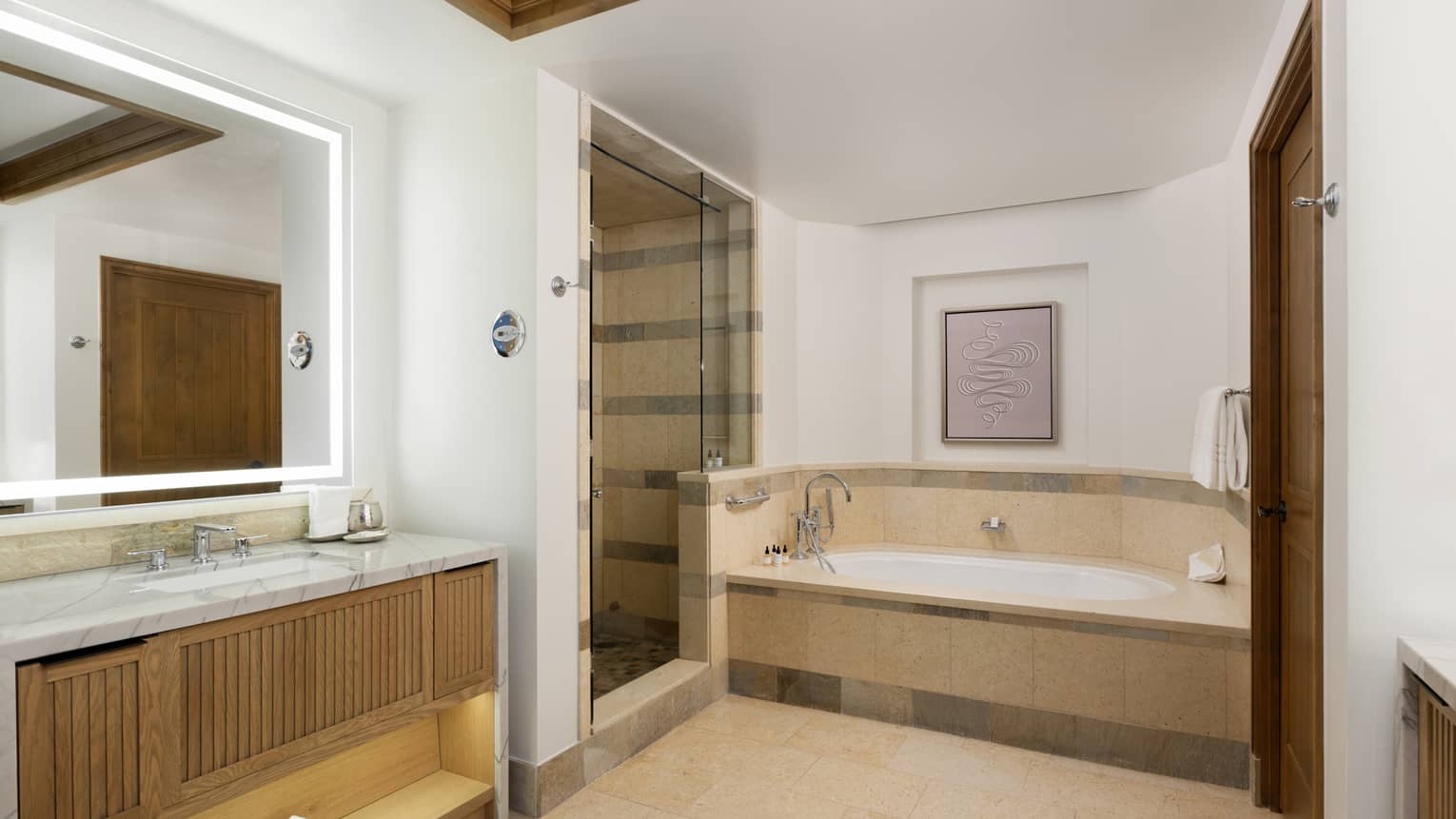 Large bathroom with limestone tile floor and sunken tub, separate walk-in shower and marble-topped vanity
