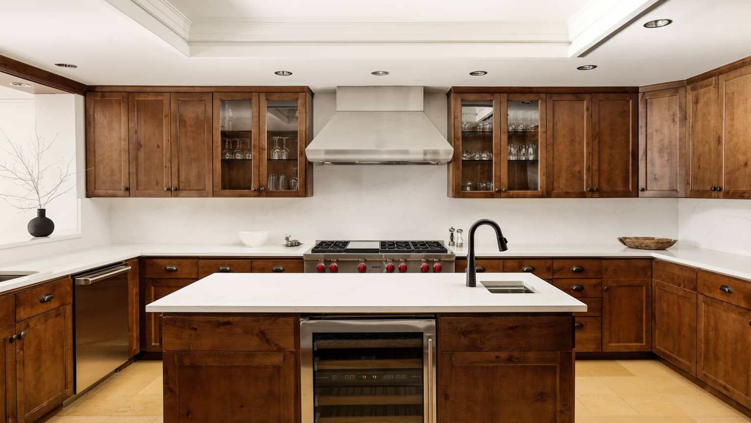 Kitchen with dark wood cupboards, island with built-in wine fridge and sink
