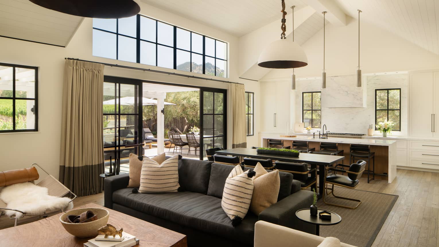 Indoor great room of a private residence with farmhouse-chic decor, including large kitchen with island