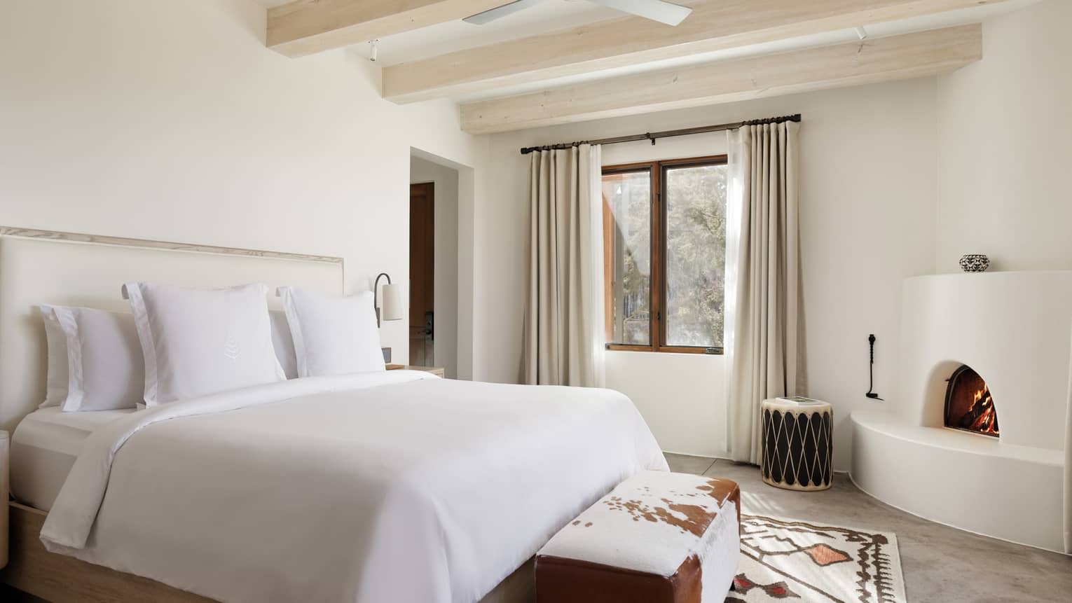 Hotel room with fireplace and beamed ceiling at Four Seasons Resort Santa Fe