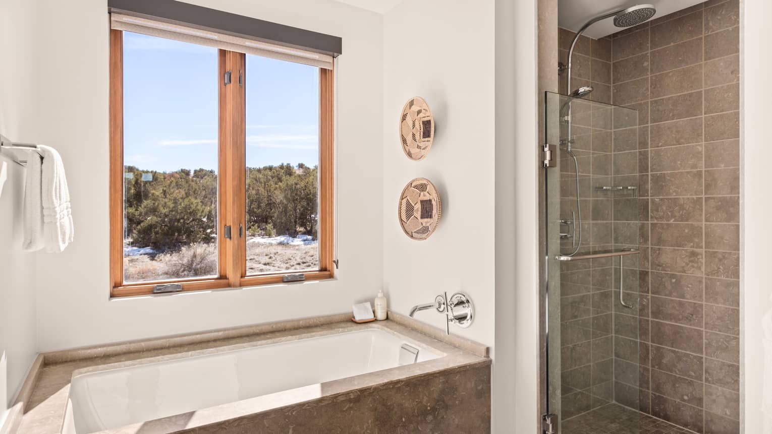 Guest room bathroom with sunken tub next to a window, and separate walk-in shower, at Four Seasons Resort Santa Fe