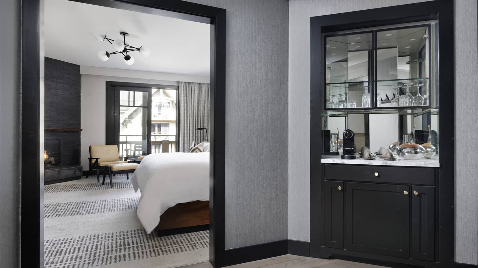 Mirrored snack bar, bedroom with bed and chaise lounge visible through doorway