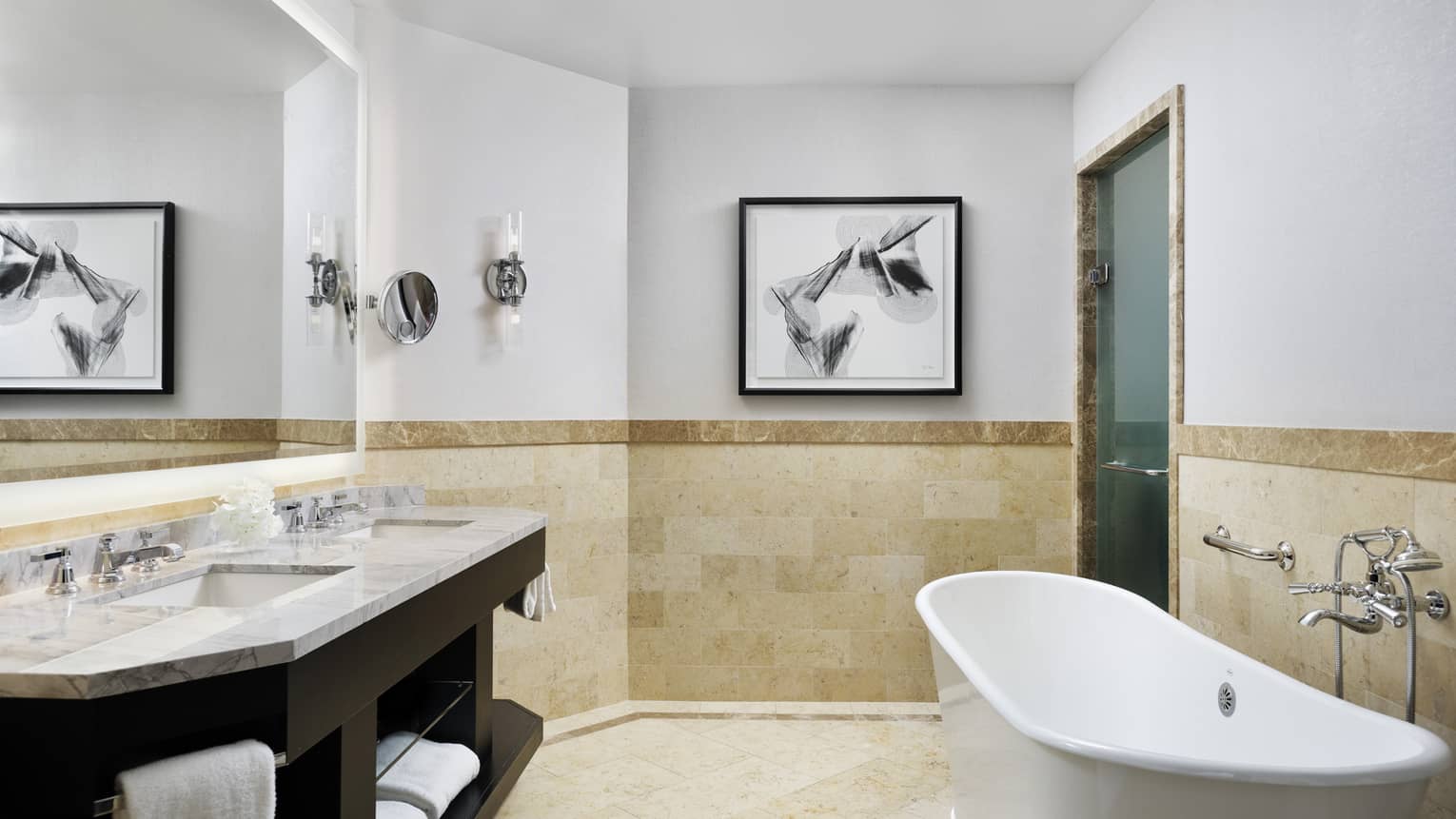 Double marbled vanity with two sinks, full-width mirror, large soaking tub, tiled wall at chair rail