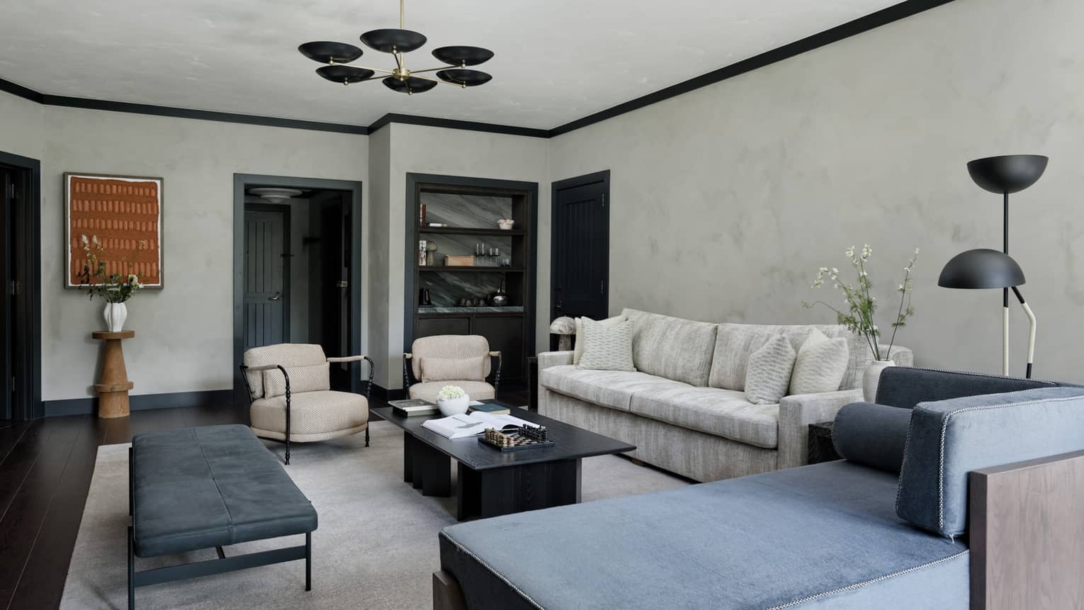 A one-bedroom suite's living room decorated in cool blue, grey and charcoal colours, at Four Seasons Vail