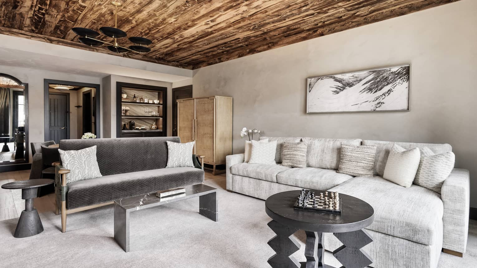 Mountain-chic living room of a hotel suite with wooden ceiling