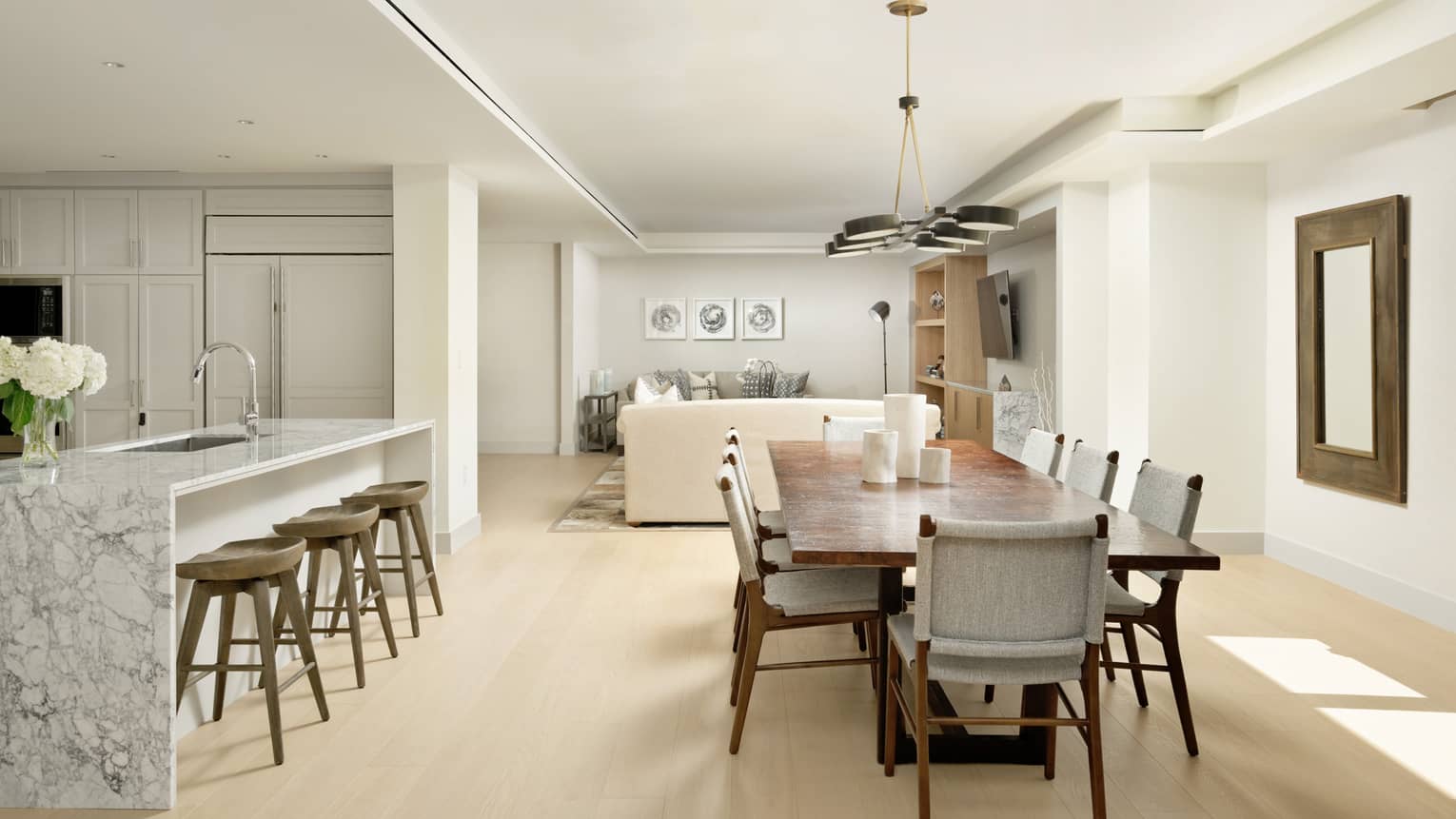 Light pours in through the windows of a neutral kitchen and dining room at a vail private residence 
