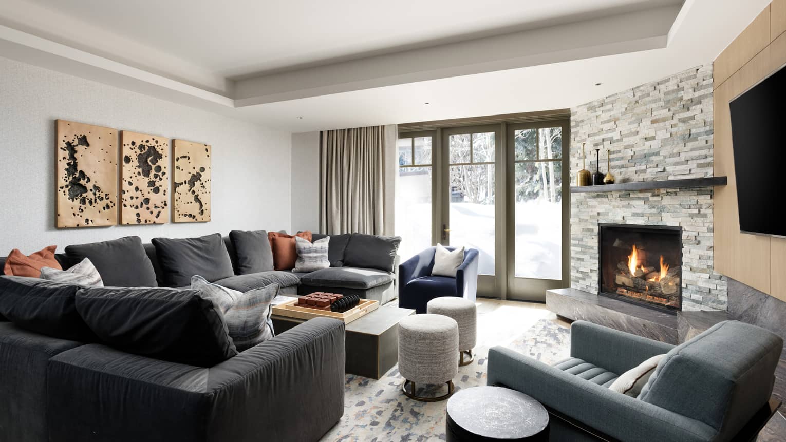 Large grey sectional sofa, fireplace, french doors to outside