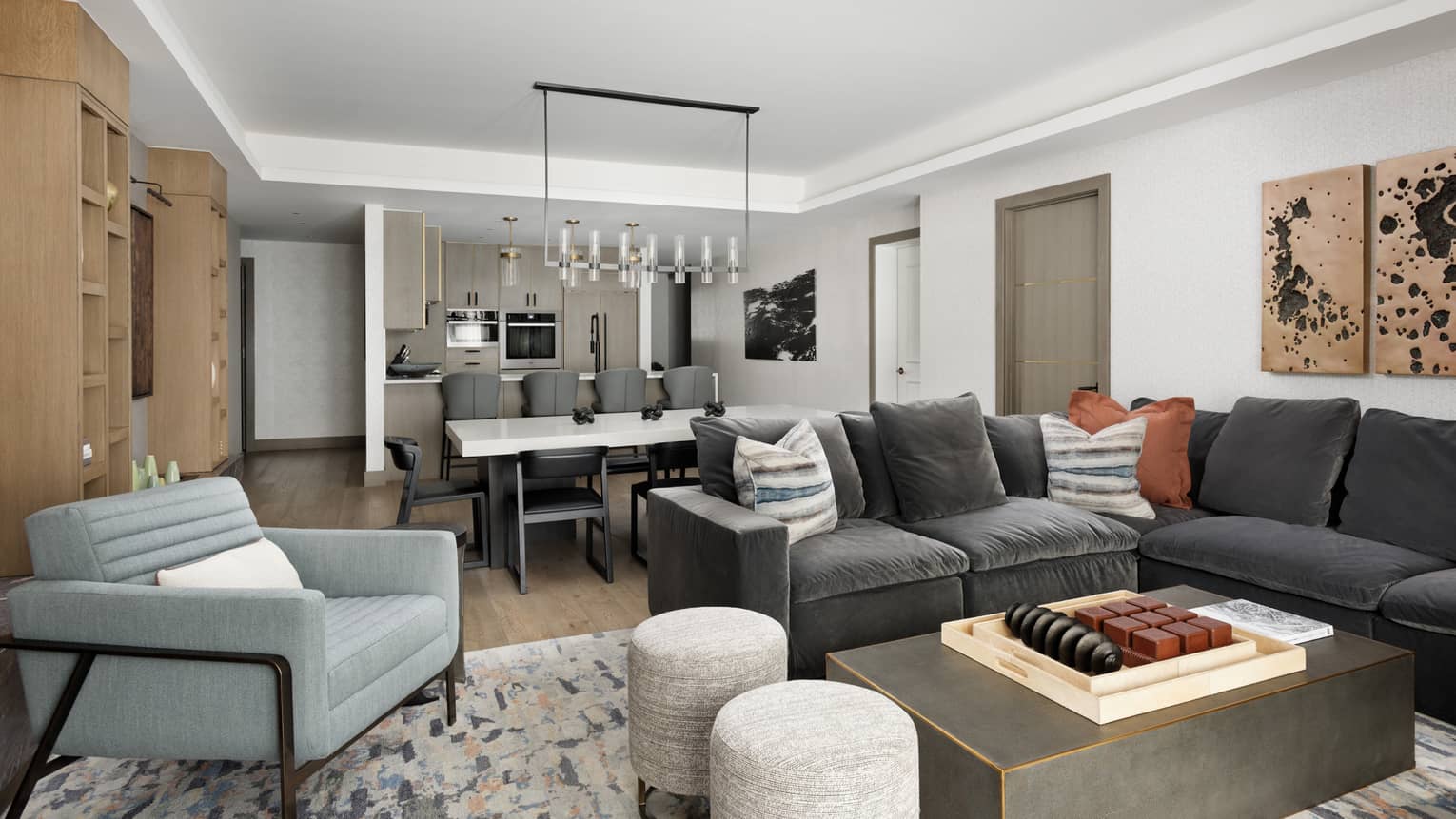 Large grey sectional sofa, light blue arm chair, two grey stools, large coffee table